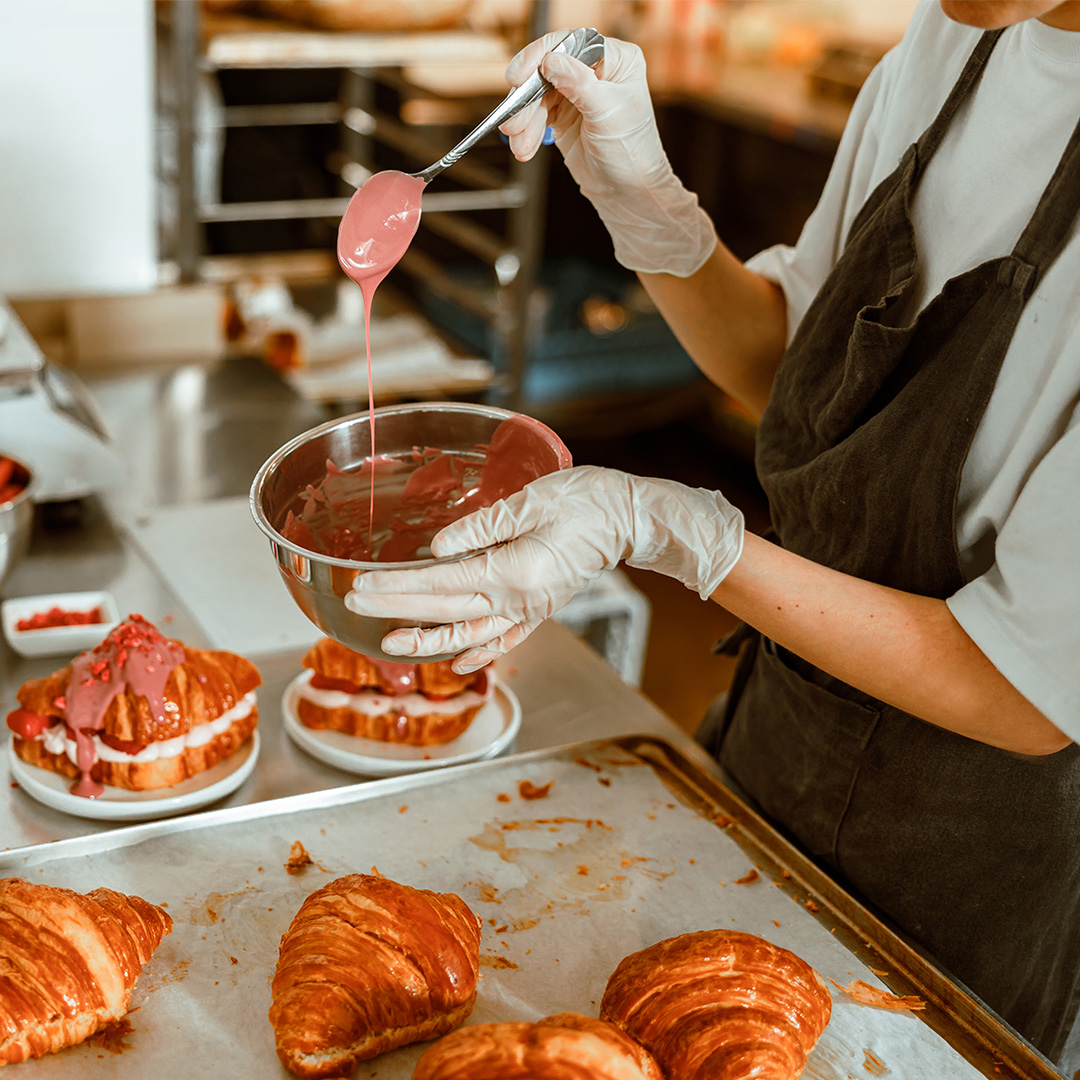 woman-holds-spoon-with-pouring-down-frosting-in-cr-2021-12-09-07-35-53-utc MANIPULADOR DE ALIMENTOS: PANADERÍA Y REPOSTERÍA 100% ONLINE
